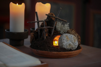 Symbole der Ostergeschichte: Die Kreuze und das Grab Jesu, davor der zur Seite gerollte Stein